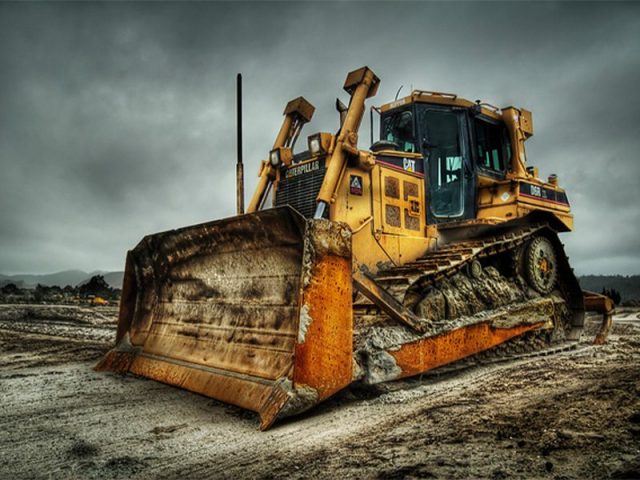 Caterpillar bulldozer parked on a construction site under an overcast sky